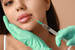 © Pixel-Shot - Beautiful woman receiving lip injection on color background, closeup