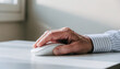 © newlifestock - Active aging person uses silver computer mouse to support economy and productivity in calm indoor environment