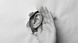 © Cliff - Conceptual image of a hand placed on a human ear emerging through torn paper, representing eavesdropping, spying, communication barriers, curiosity and secrets revealed, minimalist style