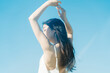 © KRN - 青空背景の夏服の若い女性
