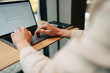 © Maskot - Hands of businessman typing mail on laptop while working at desk in coworking space
