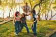 © master1305 - Friends talking by lakeside tree in warm vintage color grading. Concept of campus life, group therapy, community, friendship stories, mental wellness, and relaxed outdoor leisure.