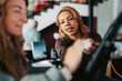 © Maskot - Female receptionist teaching registration process to businesswoman at coworking space