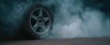 Gray tire smoke rising from whirling wheels on the asphalt road