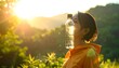 © Amat - Woman balancing clear water bottle on her forehead in a sunny, green, nature setting with golden light