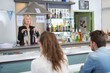 © auremar - female bartender shows how to make cocktial to trainees