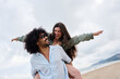© alvaro - Smiling couple enjoying piggyback ride on beach