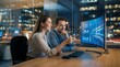 © CuteBee - Business professionals working together in modern office at night looking at data visualization on large curved computer screen while discussing project strategy and solutions