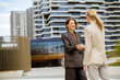 © BGStock72 - Meeting between two businesswomen in a city outside office buildings