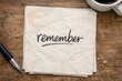 © Fotograf - A napkin with the reminder 'remember' placed next to a cup of coffee