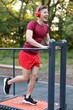 © New Africa - Young man with headphones exercising on manual treadmill at outdoor gym