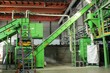 © Lidia - Green conveyor belt system and industrial sorting machinery processing waste materials in a recycling plant. Large factory line filling a white big bag container with secondary raw resource