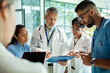 © Marko Geber - Healthcare team reviewing patient chart in hospital