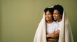 © Jumain - Happy Black Lesbian Couple Wrapped In Blanket On Green Background