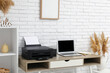 © Pixel-Shot - Modern printer with laptop on table near white brick wall in home office
