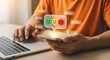 © Nakaret - A person interacts with a smartphone displaying emoticons while sitting at a desk with a laptop in a modern indoor setting.