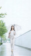 © Yka - 透明傘を差して雨の街を歩く女性の梅雨の通勤イメージ