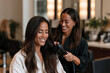 © Milos - A skilled hair stylist is seen blow-drying a client's hair, showcasing a friendly atmosphere in a salon while promoting self-care and pampering experiences for customers.