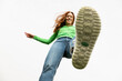 © VISTA by Westend61 - Low angle view of a stepping shoe with red hair and green shirt