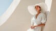 © Hot - Elegant woman dressed entirely in white summer clothing, soft beige architectural background, clean luxury fashion editorial aesthetic, ultra