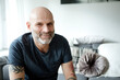 © Westend61 - Tattooed man at home sitting on couch