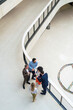 © Westend61 - Business colleagues discussing over tablet PC in office corridor