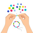© Rino - A pair of hands stringing colorful beads to create a handmade bracelet
