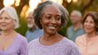© Vitalii - Group of four elderly people, two women and two men, standing in a line and smiling at the camera. the woman in the foreground is african-american and has short curly hair.