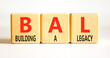 © Dzmitry - BAL building a legacy symbol. Concept words BAL building a legacy on beautiful wooden blocks. Beautiful white background. Business BAL building a legacy concept. Copy space.