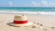 © Monster - Straw hat with red ribbon on sandy beach with ocean waves and shells