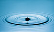 © Marykor - Close up of a blue water drop macro creating concentric ripples on a calm water surface. Abstract liquid background symbolizing purity, freshness, balance and clean water