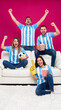 © Grow with Dani - Argentine soccer fans group celebrating on sofa with foam finger and popcorn