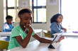 © wavebreak3 - Diverse classmates with African American boy smiling, using tablet at school with beige headphones