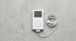 © Vitalii - Player Classic with Earbuds Flatlay on Concrete Background Retro 2000s Music Player Nostalgia