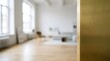 © DreamGen Works - Brushed gold metal texture foreground, blurred modern living room background, luxury interior design concept with bright minimalist loft apartment