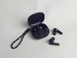 © Arina - Black wireless earphones with their case with white background isolation. Very effective and compact in its use