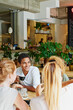 © peopleimages.com - Man, smile and friends in cafe with coffee, social gathering and bonding together on weekend break. Happy, person and group hangout in restaurant with beverage, hospitality and listening to gossip.