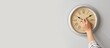© Pixel-Shot - Hand with clock on light wall. Banner for design