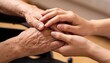 © serg9768608 - Hands of an elderly and a young man touching each other.