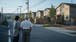 © bephoto - 復興後の住宅地で日本人夫婦が新しい家並みを見つめる朝の場面
