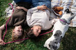 © ADDICTIVE STOCK - Couple relaxing on picnic blanket with dog in park