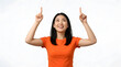 © Donnangelo - Young Asian woman smiling and pointing upwards with both index fingers, indicating a direction or highlighting something above PNG Isolated on transparent background