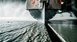 © EVA SOFIA VISSER - Industrial concrete saw cutting through a floor with water spray. Heavy-duty machinery performing precision masonry work on a construction site. Infrastructure development and repair concept.