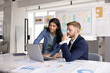 © fizkes - Young 30s Indian woman showing presentation on laptop to man colleague or consulting company client during formal meeting in modern conference room. Analytics, teamwork, strategy planning in workplace