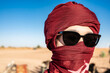 © Cavan Images - portrait of woman wearing a turban in the Sahara desert
