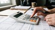 © 7IMJAGO - Hands using calculator with financial documents, tax forms and pen on office desk for accounting work