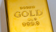 © yadytt - Close up of a shiny gold bullion bar, stamped with 'GOLD' and '999.9' purity, representing wealth and investment
