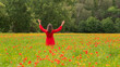 © Milou Dirks - happy woman in red dress in wild poppy flower field