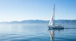© Platon - Small white sailboat moving slowly on a perfectly calm, reflective blue sea with soft foggy mountains in the background