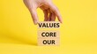 © Pixel Commerce Co - Hand holding wooden blocks with core values text on yellow background